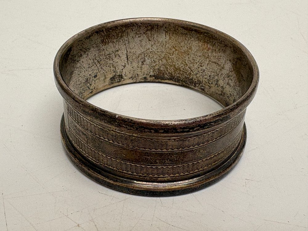 Lot 557: A British Sterling Silver Engine-Turned Napkin Ring circa 12.65g