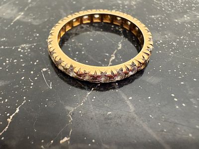 A 9ct yellow gold spinel eternity ring Gross 2.73g Size M. A 9ct yellow gold eternity band 