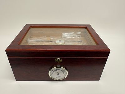 A contemporary glass-top wood cigar humidor with multiple hygrometers. A contemporary wood and 