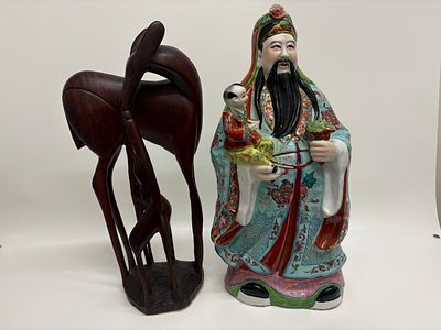 A Chinese polychrome porcelain figure of Lu Xing and a carved hardwood deer sculpture. A Chinese 