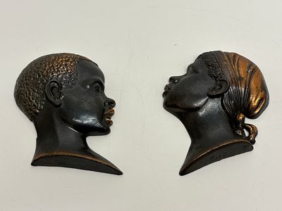 GWG, A Pair of Africanist Profile Wall Plaques, Hollow-Cast Metal. A pair of mid-20th century 