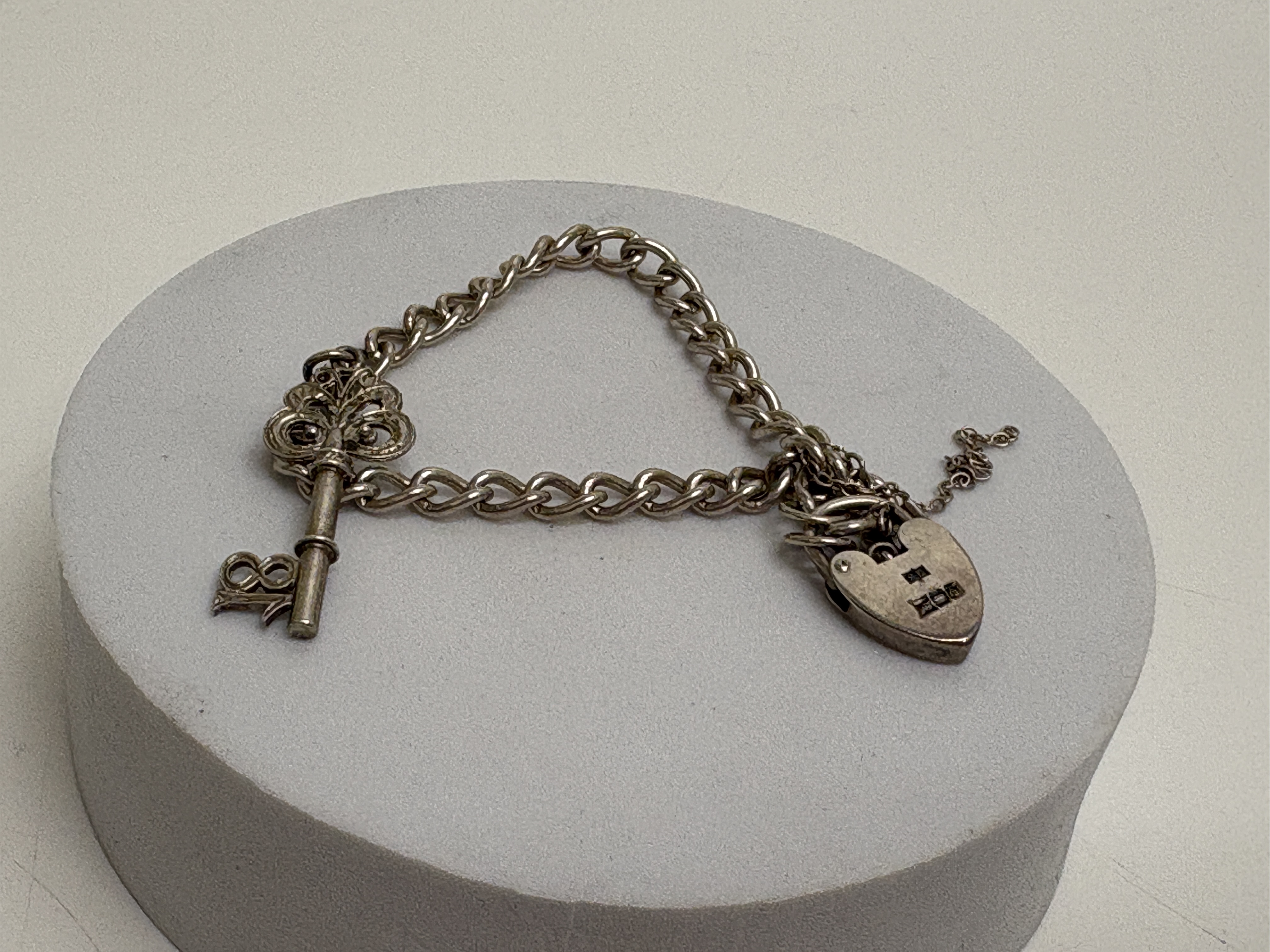 A Vintage Hallmarked Sterling Silver Curb-Link Charm Bracelet with Heart Padlock Clasp and 18th Birthday Key Charm circa 11.66g
