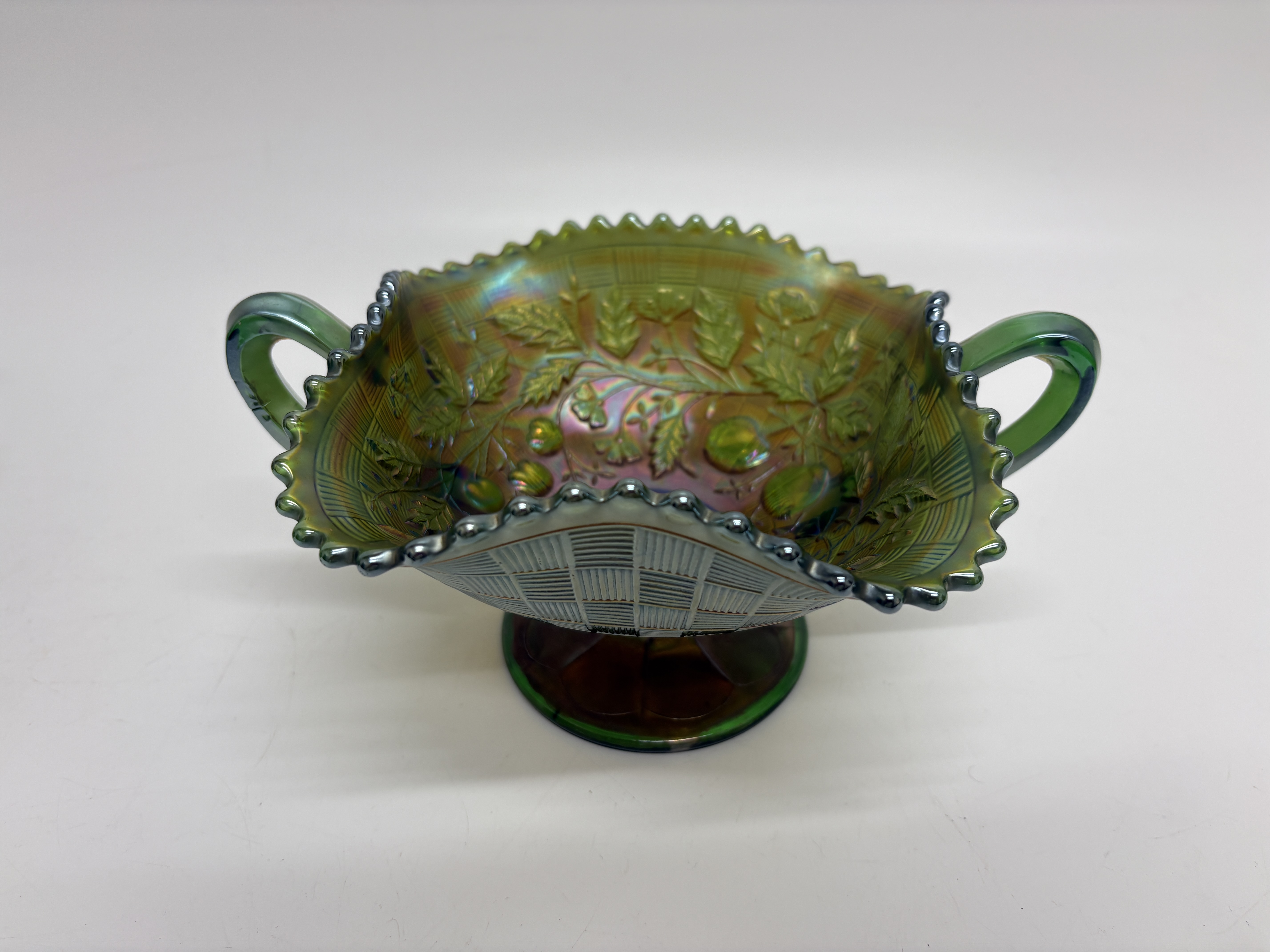 A Northwood Fruits and Flowers pattern green carnival glass footed bonbon