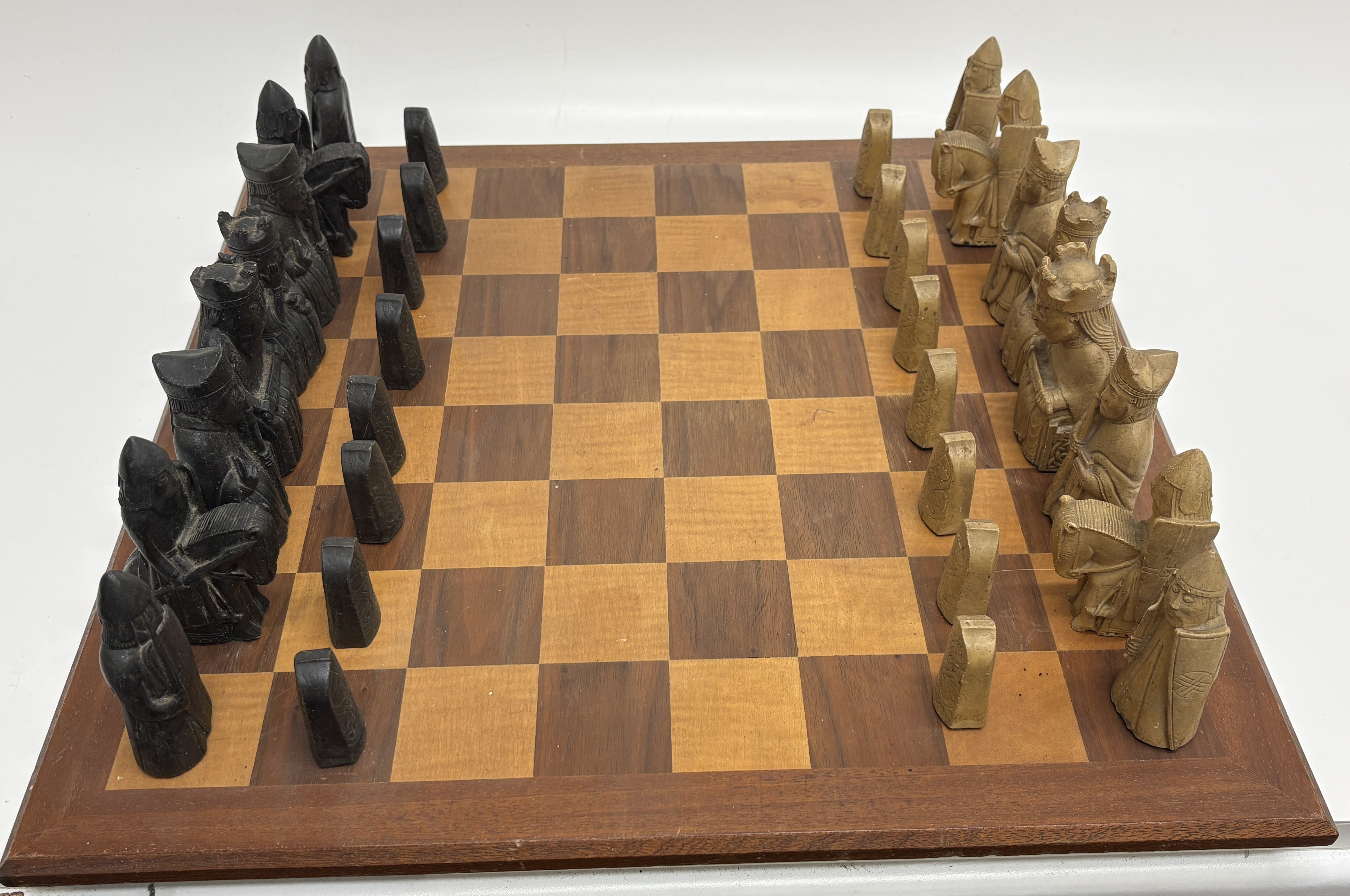A Set of Lewis Chessmen Replica Chess Pieces and a Wooden Game Board