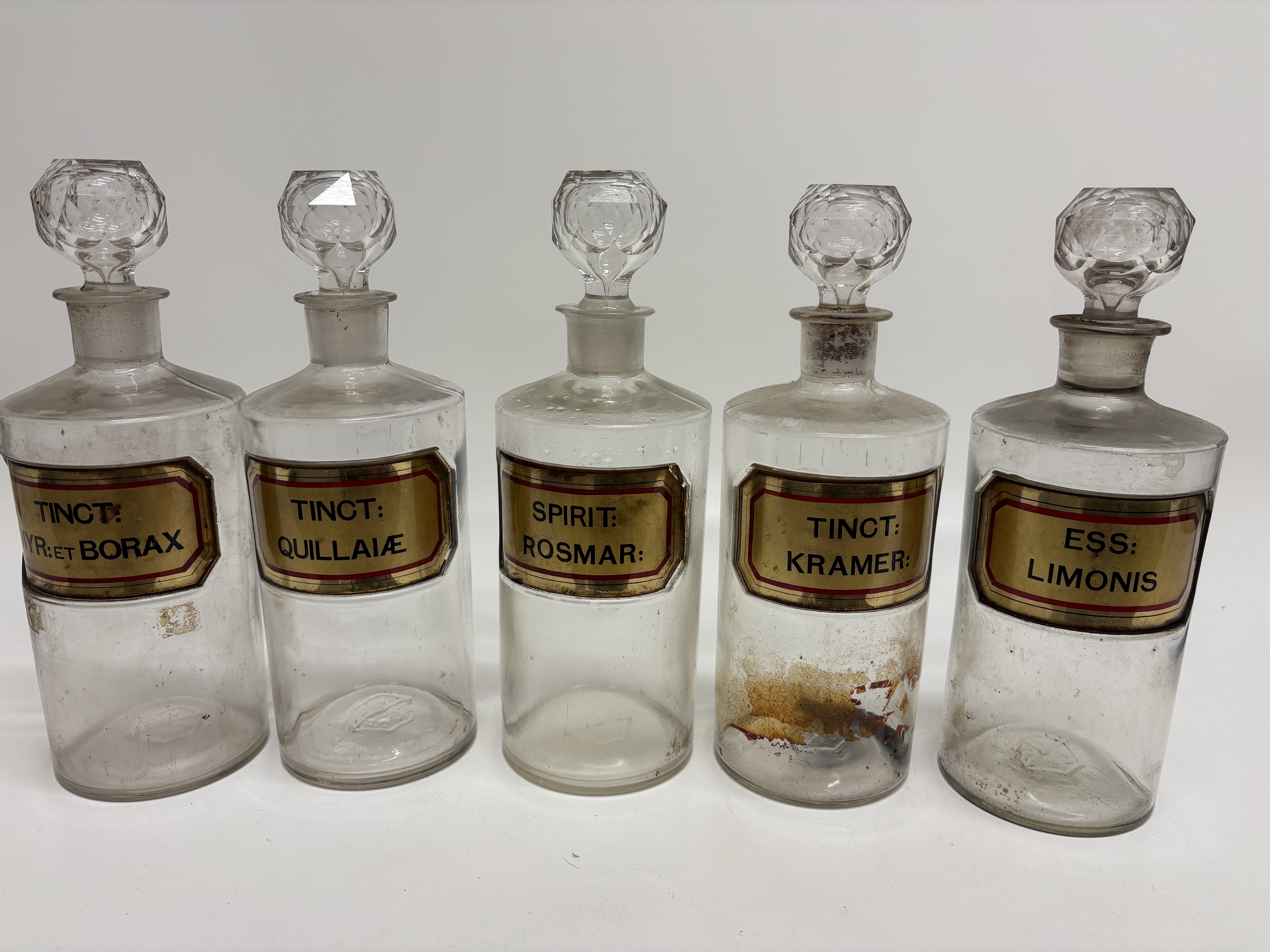A set of five late 19th-century glass apothecary jars with faceted stoppers and gilt labels Height 26cm