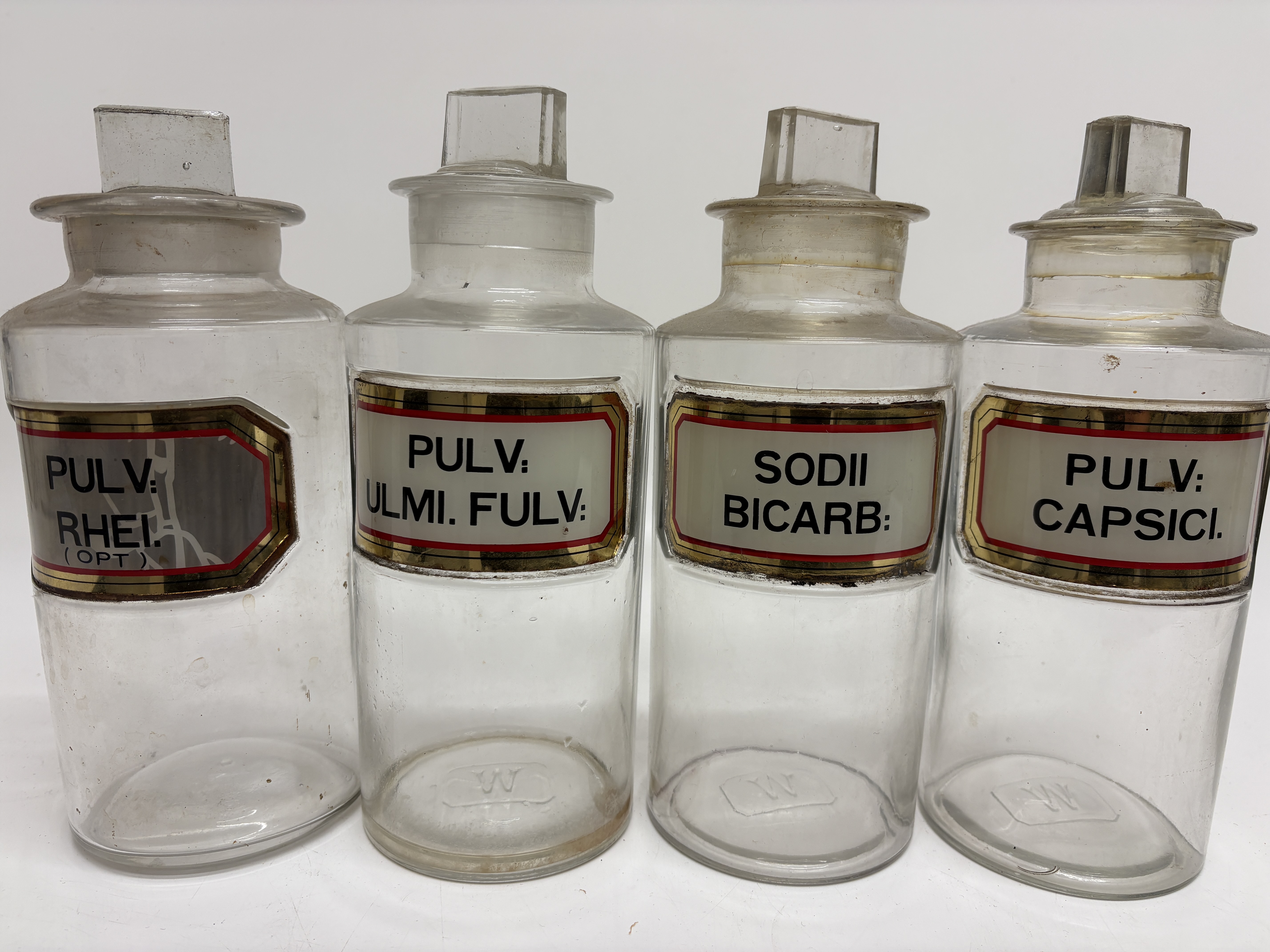 A set of four Whitall Tatum and Co antique glass apothecary jars with glass labels 22cm Tall