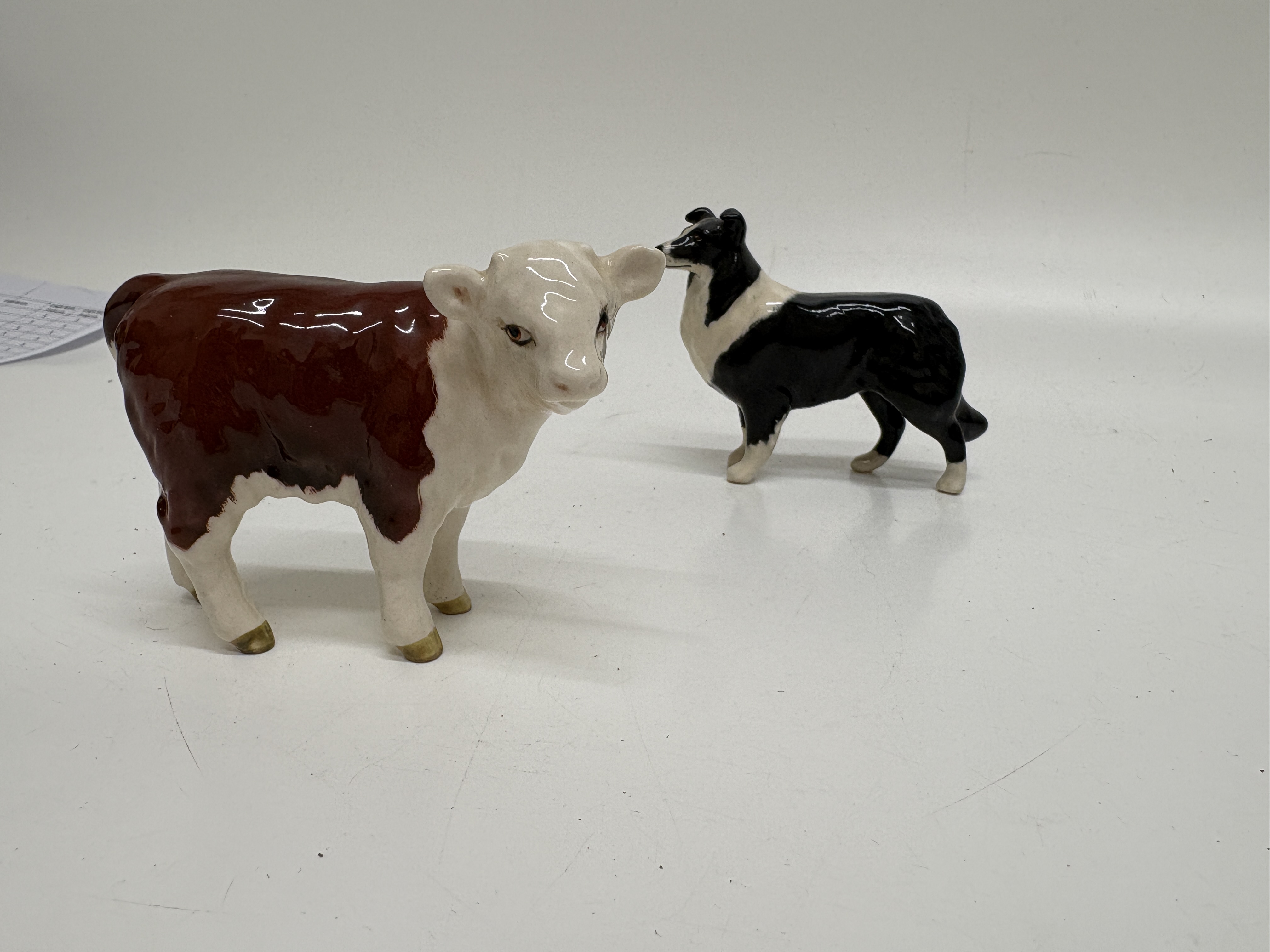 Two Beswick Glazed Ceramic Animal Figurines comprising a Hereford Calf and a Collie