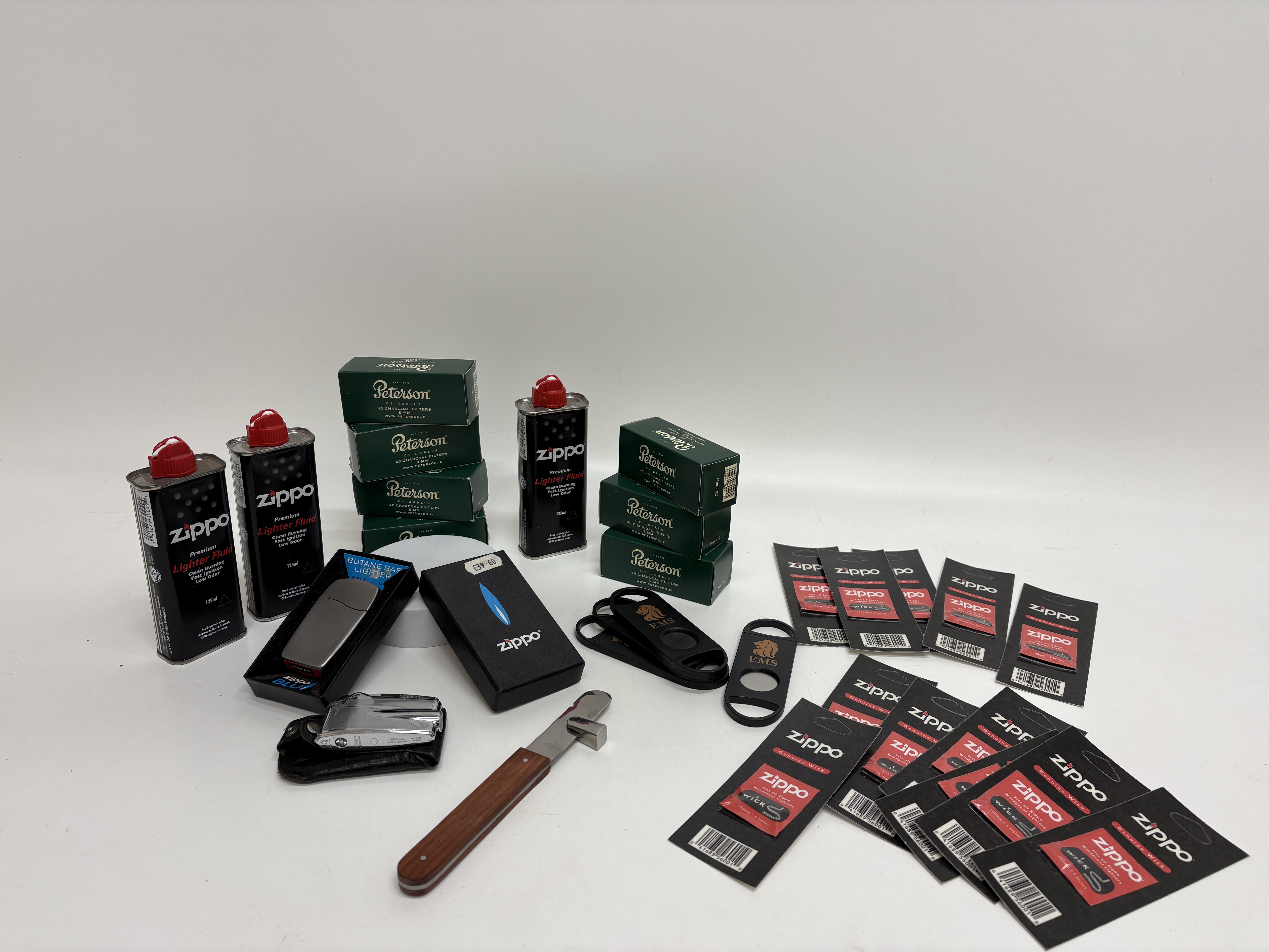 A Collection of Smoking Accessories including Zippo and Ronson Lighters, EMS Cigar Cutters, and Consumables