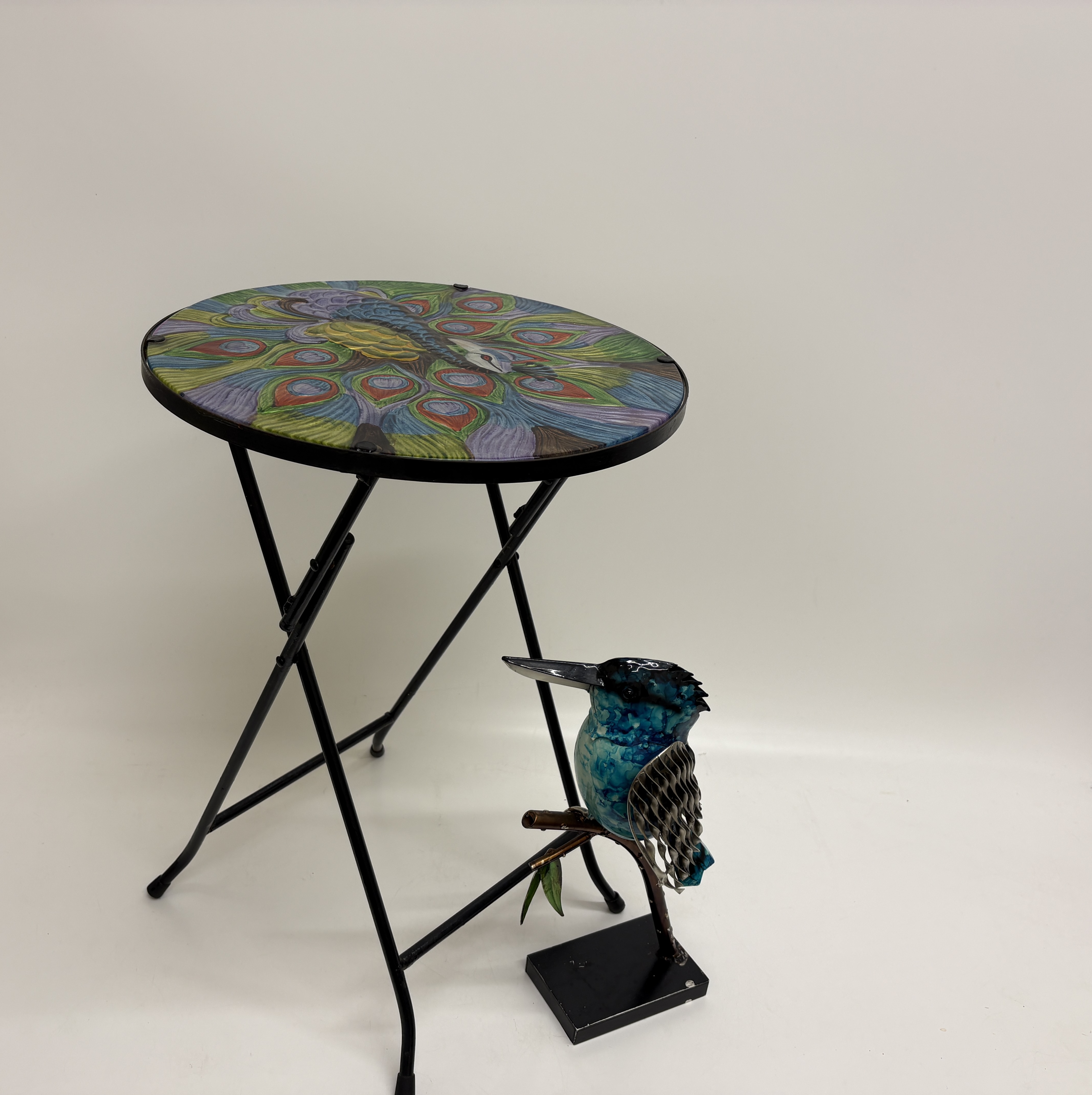 Two decorative outdoor items comprising a Belavi glass-topped folding bistro table and a metal kingfisher sculpture
