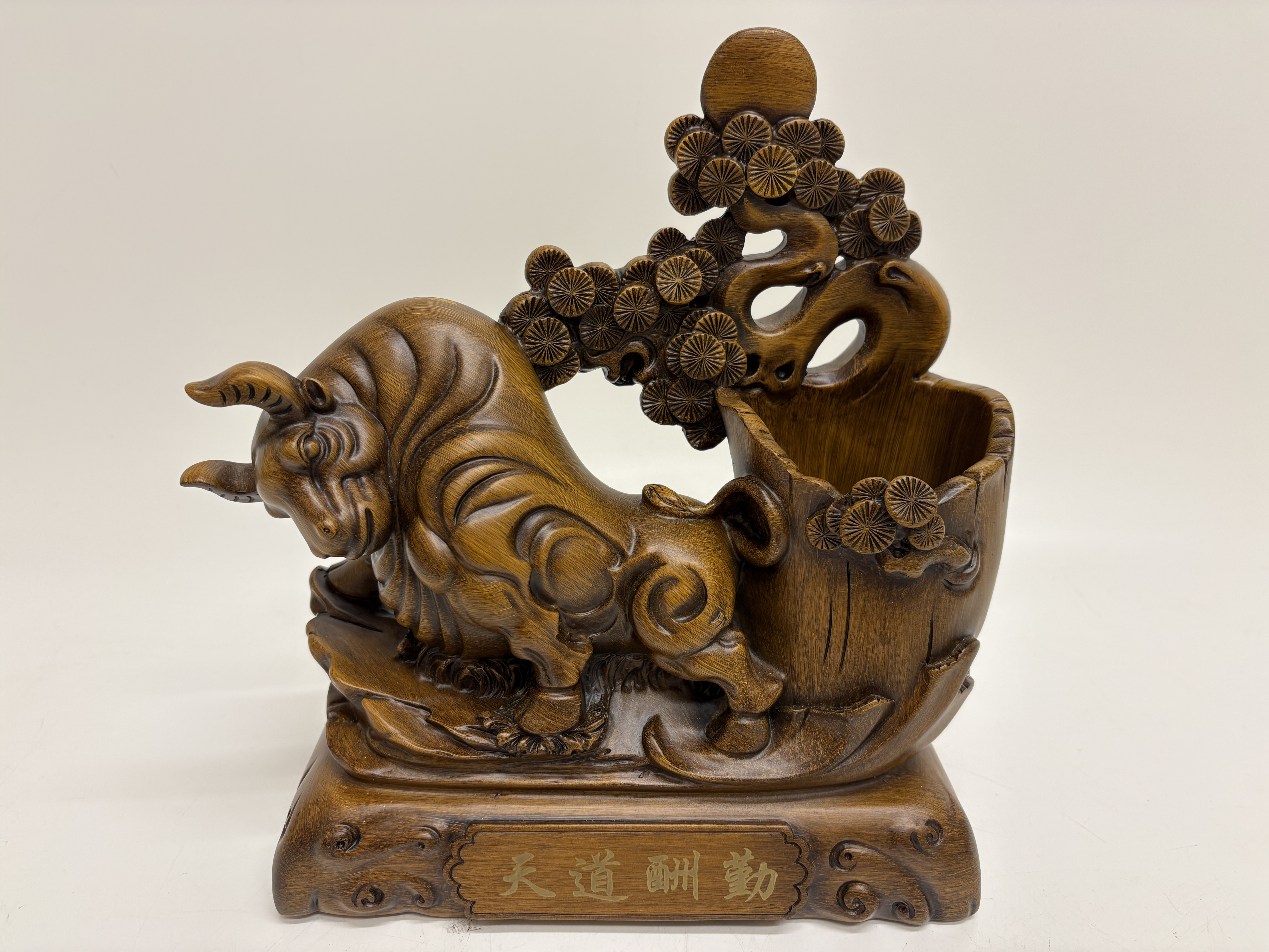 A contemporary Chinese simulated wood resin bull ornament and pen holder