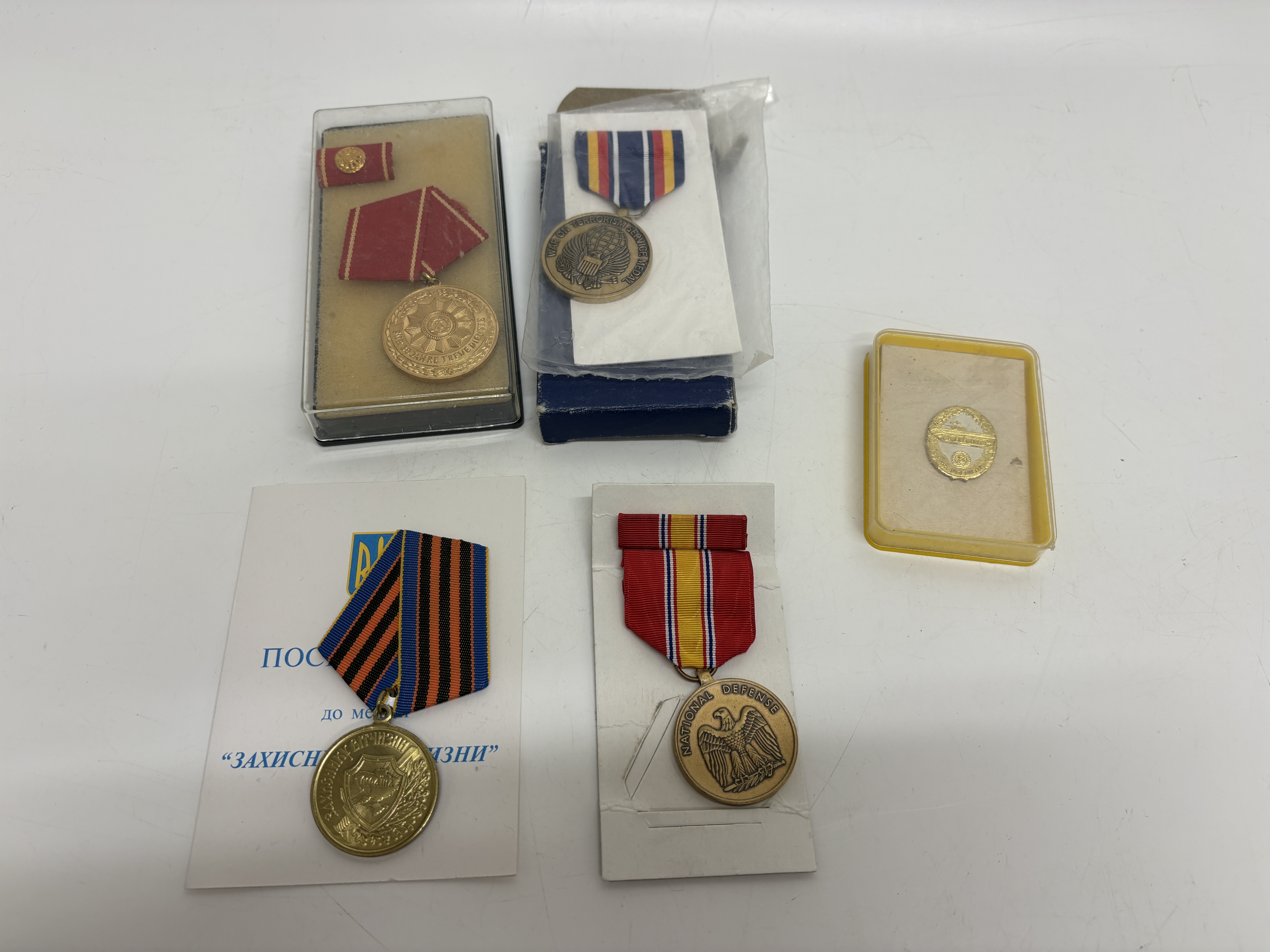 A Collection of Original International Military Medals and Badges Including United States and Ukrainian Examples
