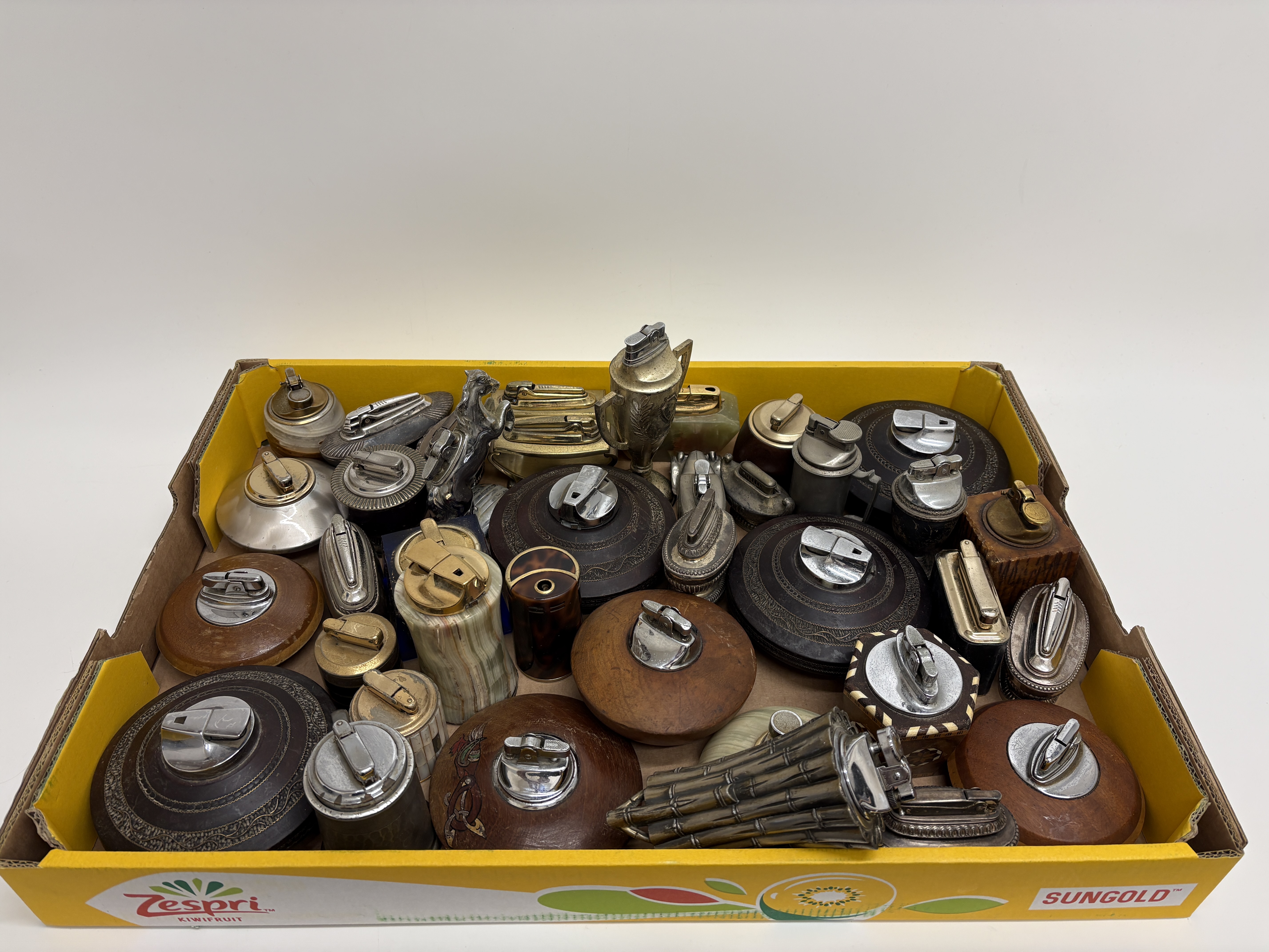 A collection of vintage mid-20th-century table lighters in wood stone and novelty metal cases