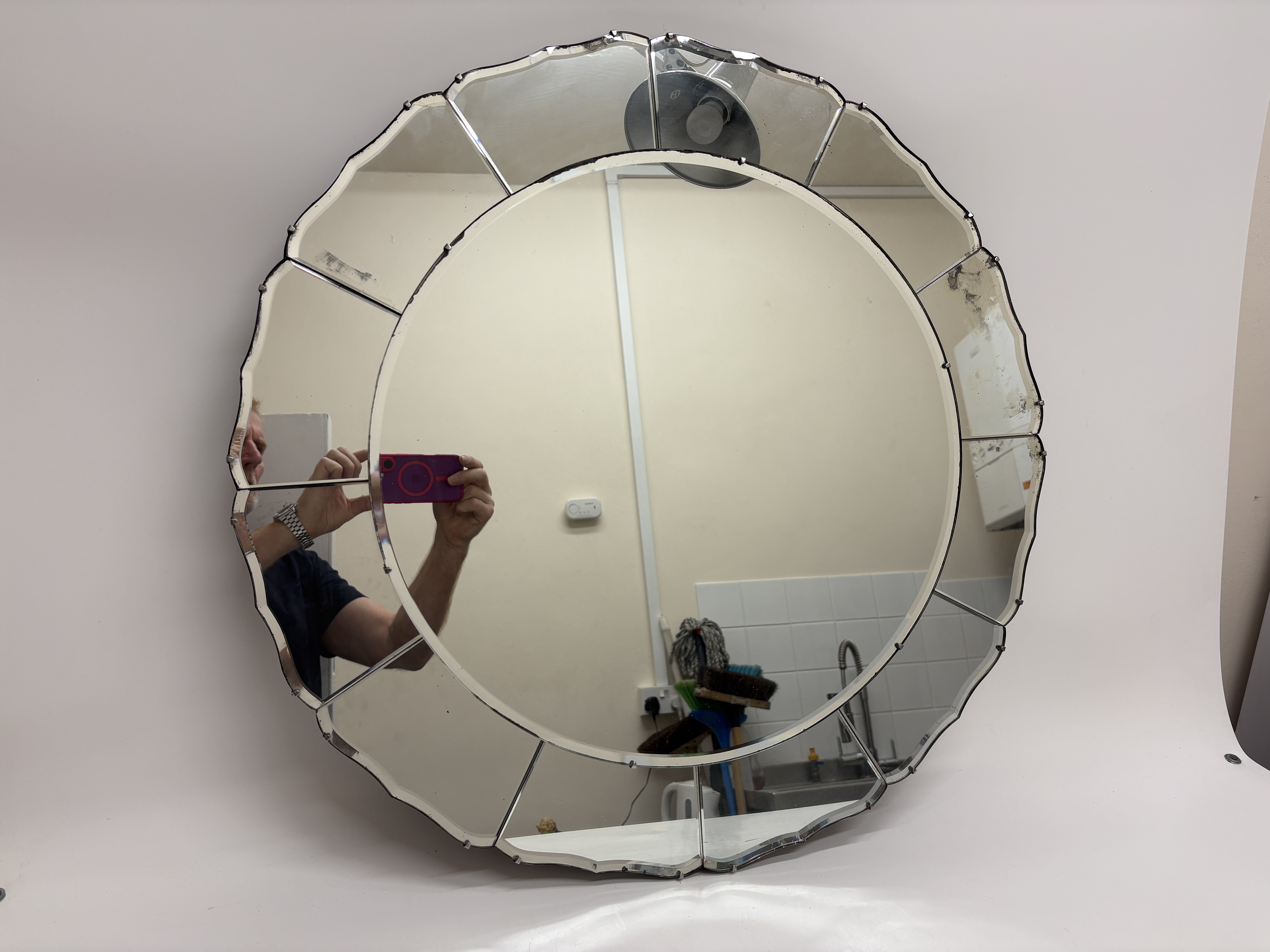 An Art Deco circular wall mirror with bevelled petal border 71cm wide