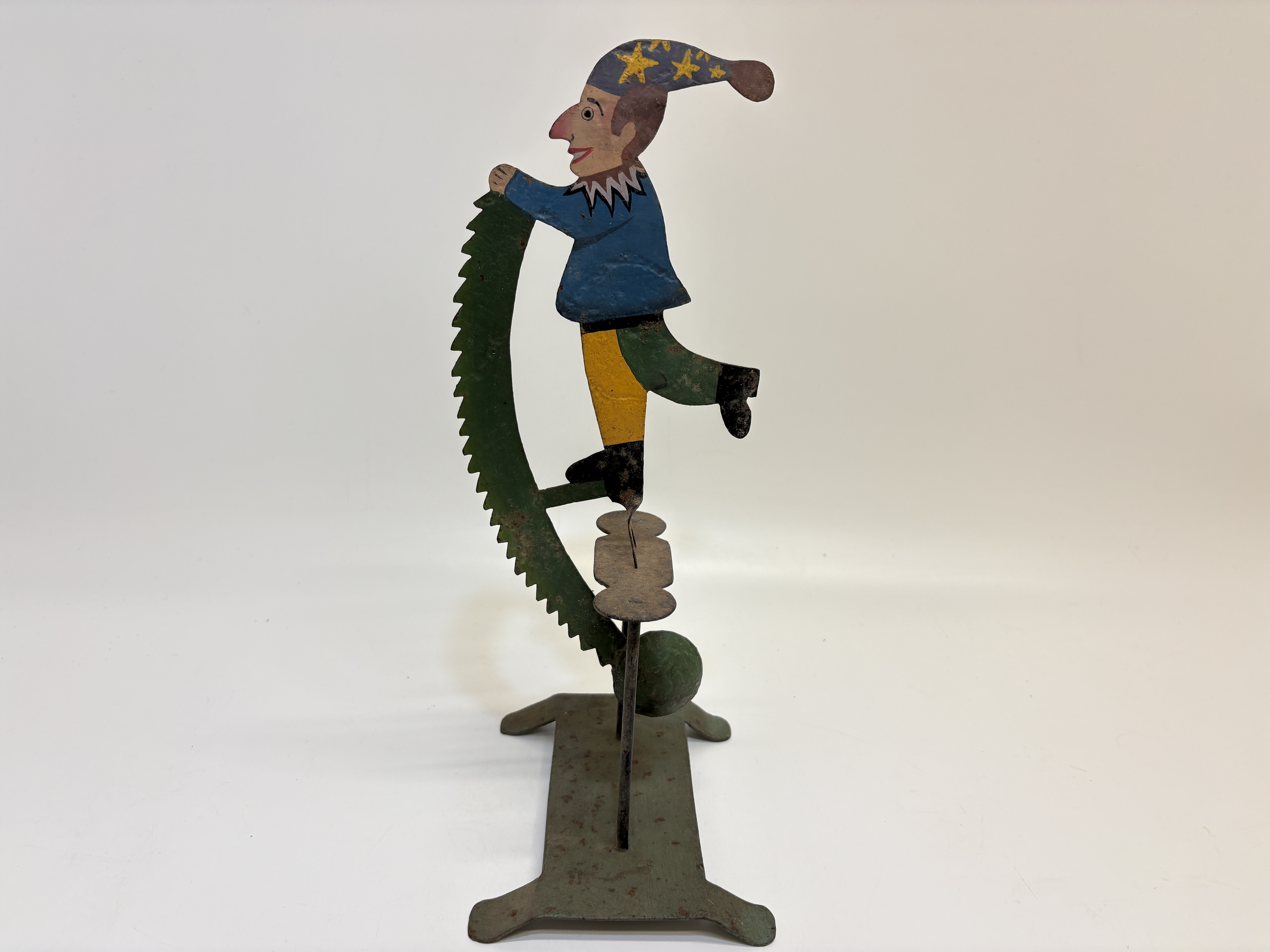 Vintage hand-painted jester and saw pendulum balance toy on stand 34cm tall