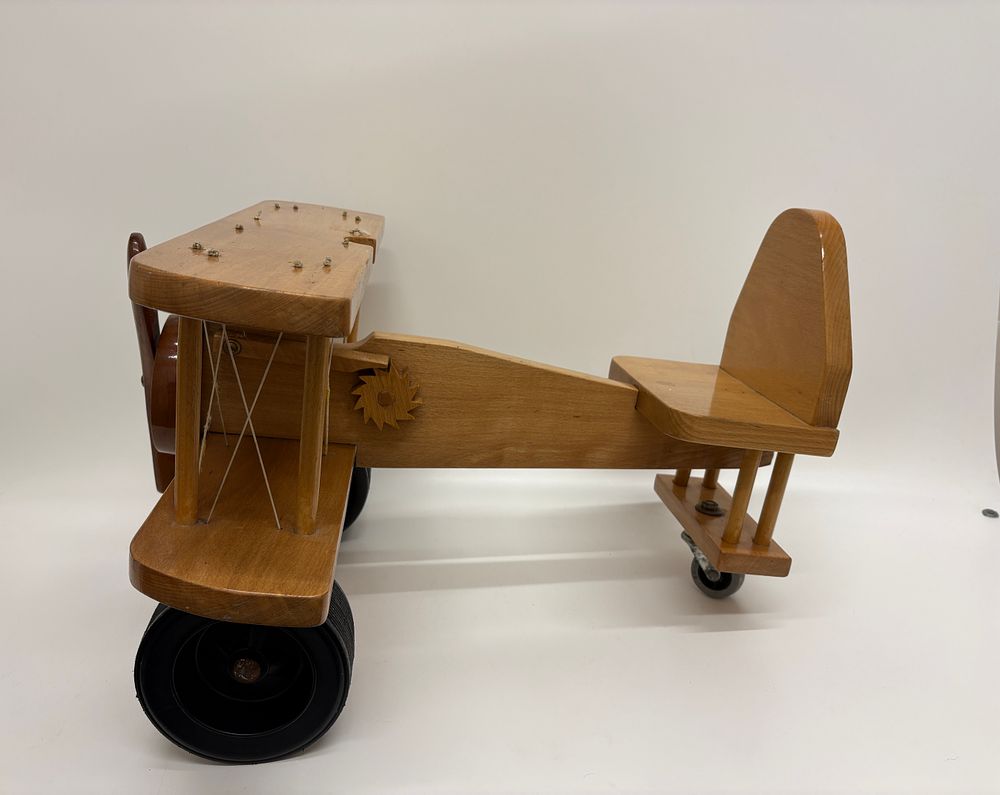 Lot 526: Large wooden biplane sit on toy with hand-cranked clicking mechanism