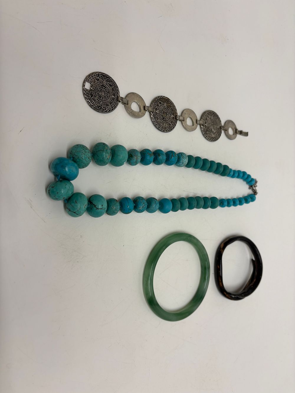 Lot 704: An Assortment of Jewellery comprising a Mexican Sterling Silver Bracelet a Graduated Turquoise Stone Necklace and Two Bangles silver content circa 44.2g 925