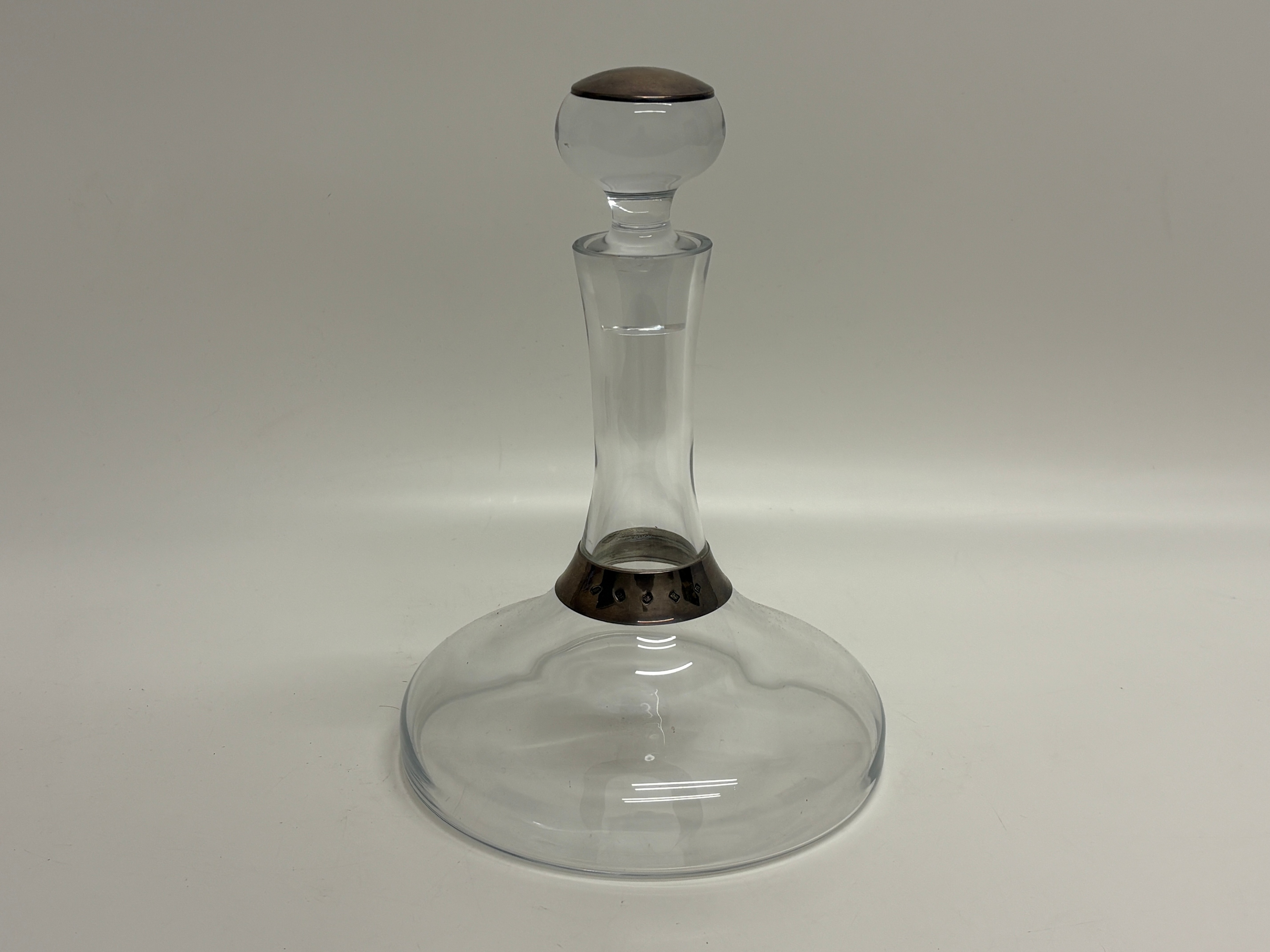 A clear glass ship's decanter with sterling silver mounts