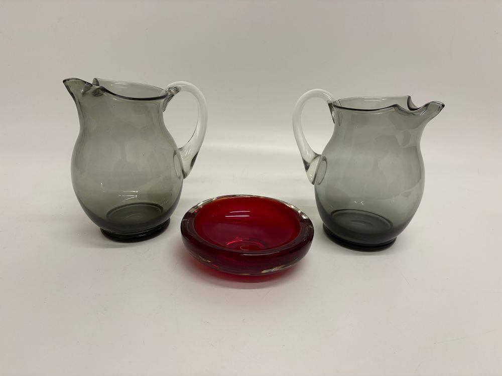 Lot 504: A Trio of Mid-Century Modern Art Glass Comprising a Pair of Smoke Grey Pitchers and a Ruby Red Sommerso Bowl