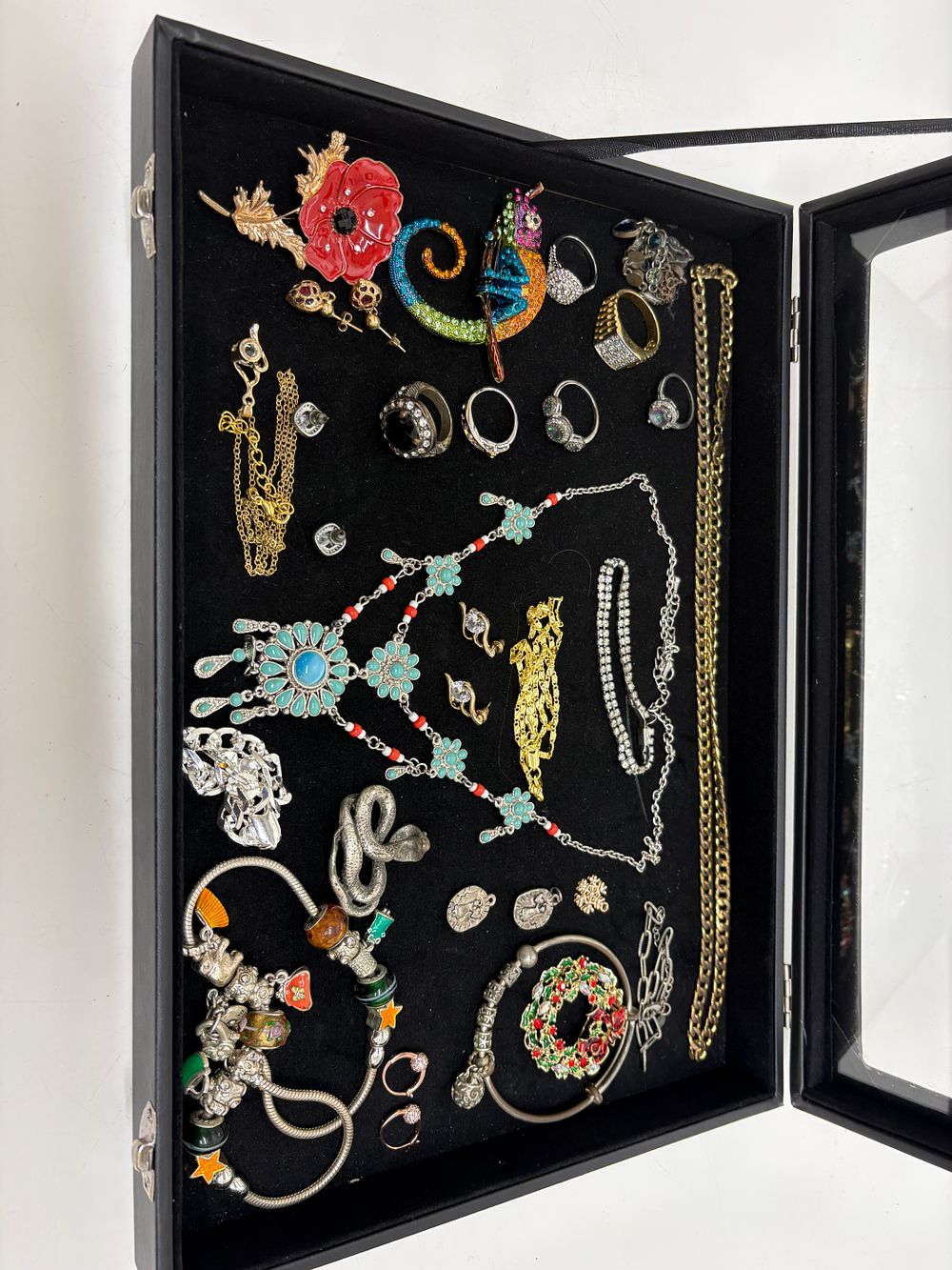 Lot 57: An Assortment of Costume Jewellery including Brooches, Rings, and a Charm Bracelet