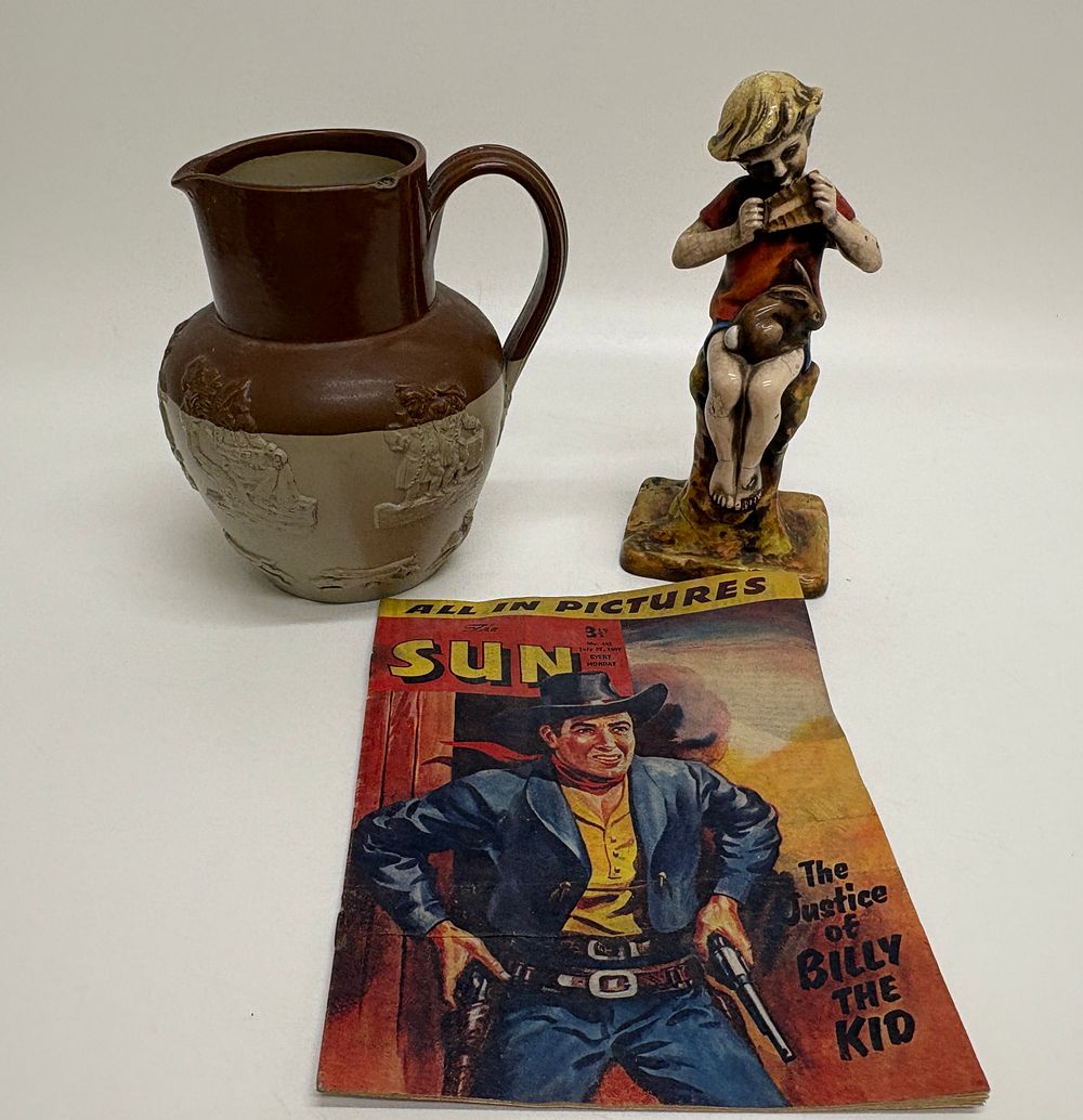 Lot 266: A Trio of items comprising a Royal Worcester Peter Pan figurine, a salt-glazed stoneware jug, and a 1957 copy of The Sun comic