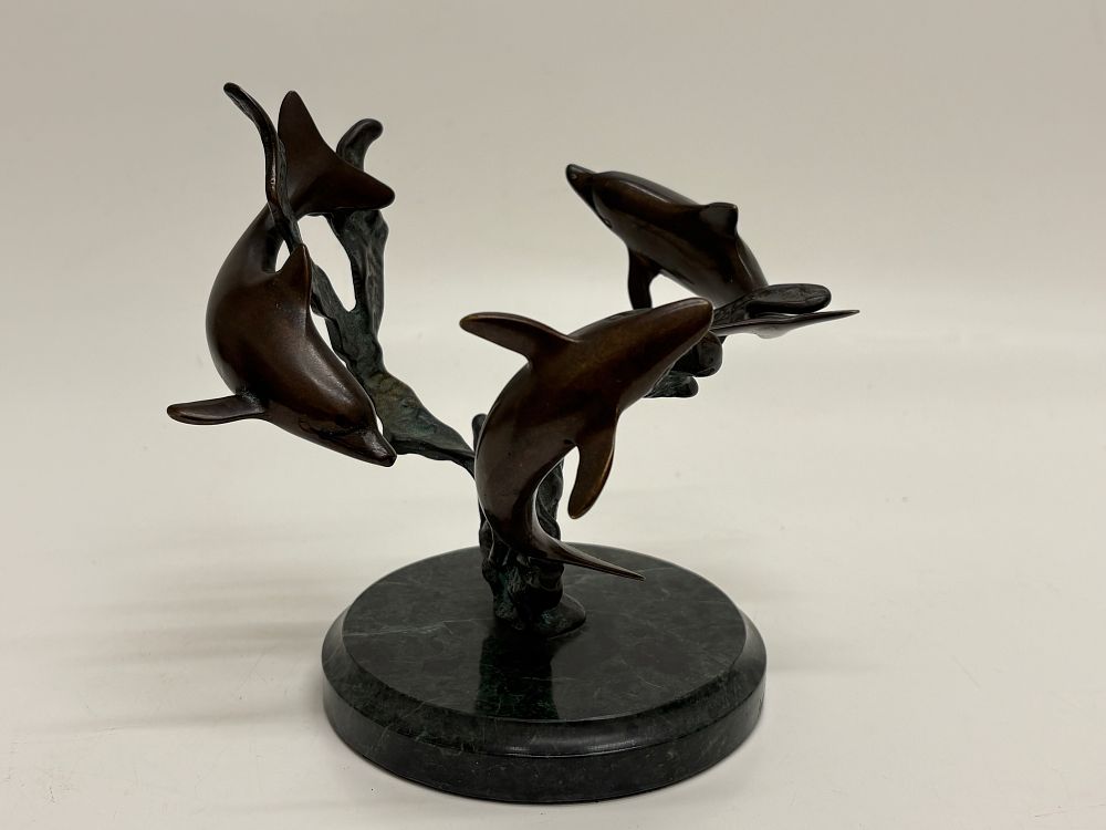 Lot 218: A Group of Cast Bronze Swimming Dolphins on a Green Marble Base