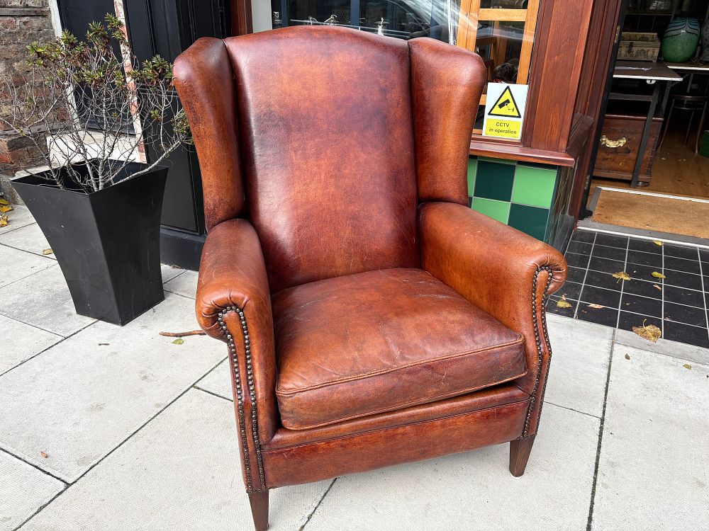 Lot 405: A Vintage Wingback Armchair in Cognac Leather