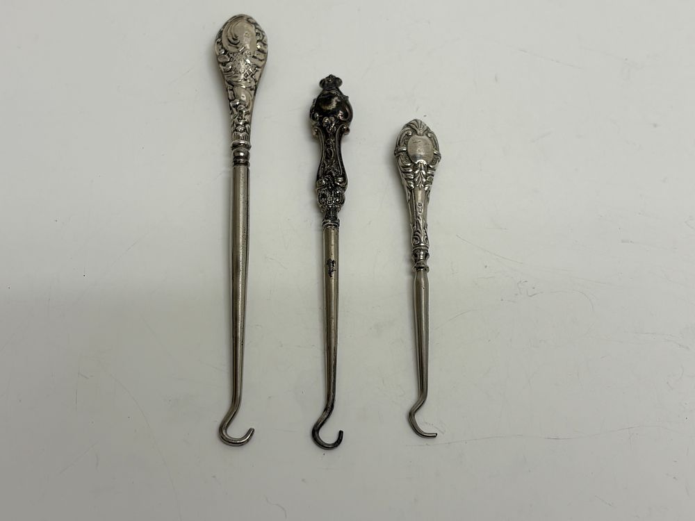 Lot 60: A Trio of Edwardian and Late Victorian Sterling Silver Handled Button Hooks gross circa 55g