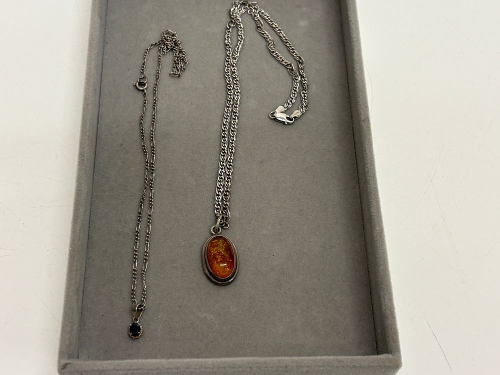 Lot 73: Two sterling silver pendant necklaces including Baltic amber and faceted dark gemstone