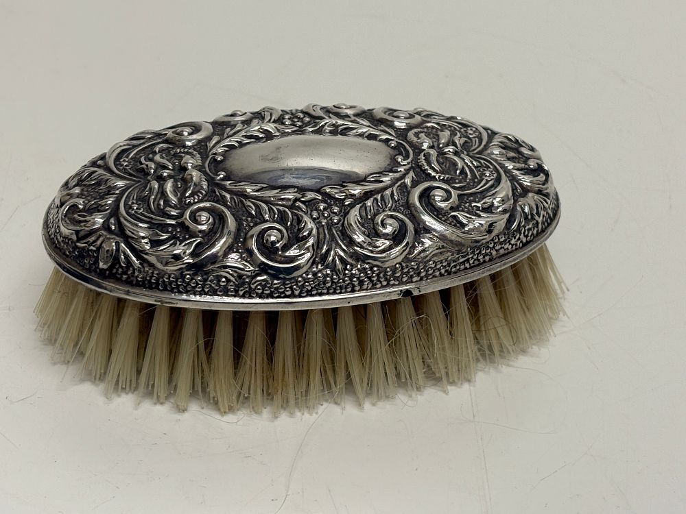 Lot 94: An Edwardian Sterling Silver Repousse Hair Brush by Broadway & Co Birmingham 1905