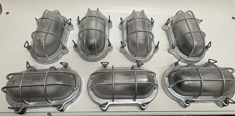 Lot 699: A Set of Seven Industrial Cast Aluminium Caged Bulkhead Light Fixtures