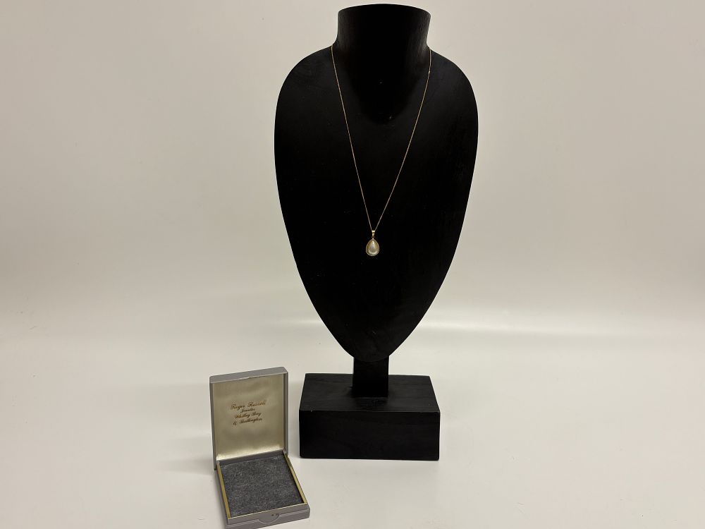 Lot 26: A 9 carat yellow gold and mother-of-pearl teardrop pendant on chain Gross Circa 1.89g