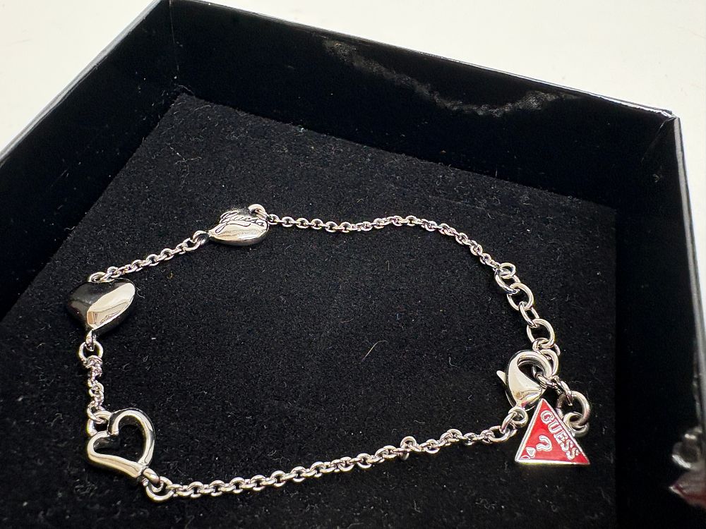 Lot 36: A Guess Silver-Tone Heart Motif Charm Bracelet