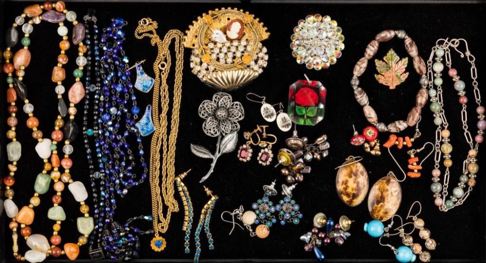 Stone, Rhinestone, & Coral Jewelry. 26 pieces of costume jewelry featuring a 32" polished stone 