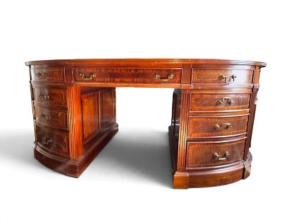 English Antique-Style Oval Partners Desk. English antique-style crotch grain mahogany, with 
