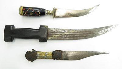 THREE MIDDLE EASTERN DAGGERS. Grips of wood and horn, curved blades, one inscribed in 