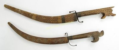 TWO ALGERIAN NIMCHA DAGGERS. The wooden mounts carved and inlaid with wire. With characteristic 