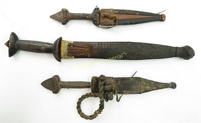 THREE AFRICAN DAGGERS. All with handwrought, double-edged blades, two with embossed leather 