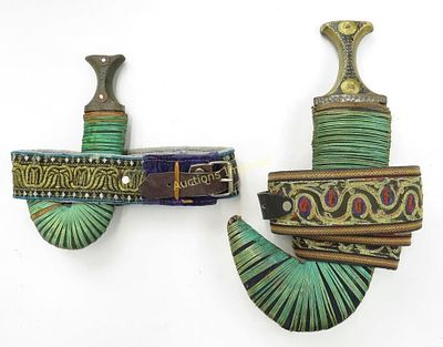 TWO ARAB KHANJAR DAGGERS. Omani work, one for a child. Each with horn hilt and leather-covered 