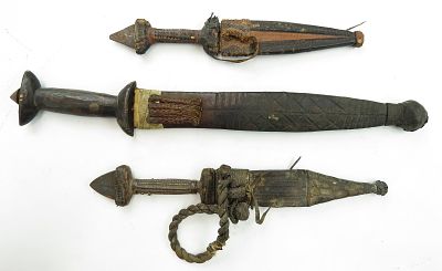 THREE AFRICAN DAGGERS. All with handwrought, double-edged blades, two with embossed leather 