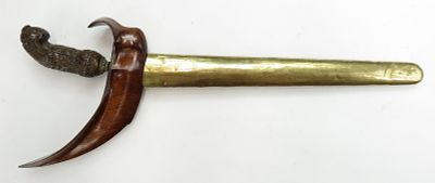 AN INDONESIAN KRIS SWORD. With carved wooden grip and scabbard, the waved blade double-edged and 