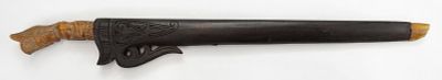 A SUMBAWAN SWORD. The carved bone handle in the form of a seated deity, the straight 