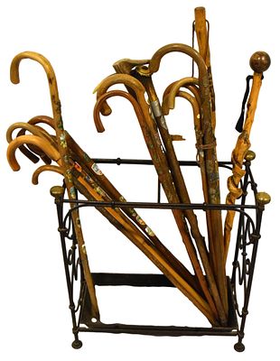 Schirmst&auml;nder mit zw&ouml;lf St&ouml;cken. Gusseisen, Seiten verziert, mit vier Messingkugeln, mit zw&ouml;lf 