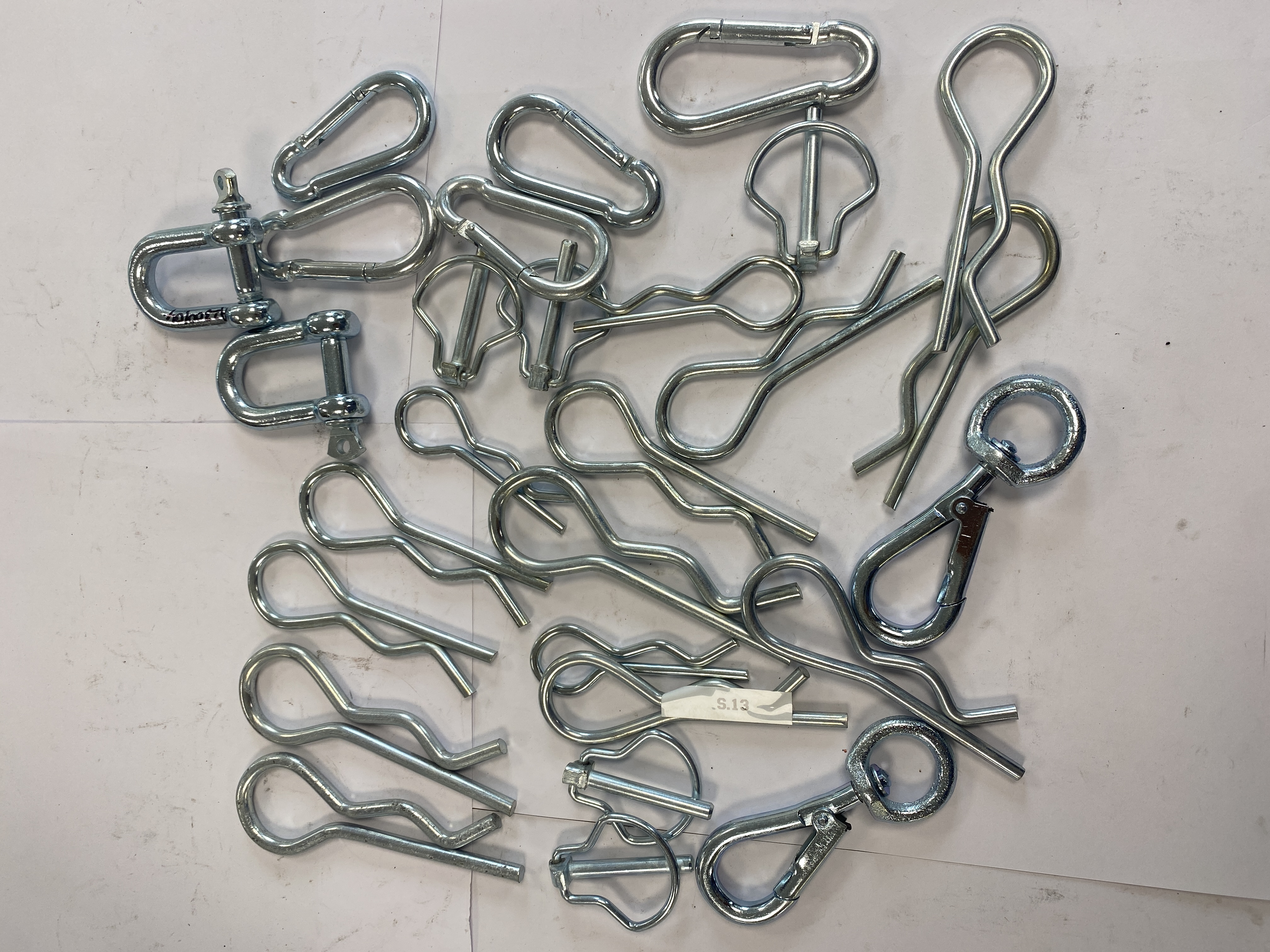 * An Assortment of Zinc-Plated Steel Utility Hardware Including Hitch Pins, Snap Hooks, and Shackles