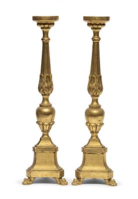 COPPIA DI CANDELIERI IN LEGNO DORATO, INIZI XIX SECOLO con fusto incamiciato a foglie e piedi 