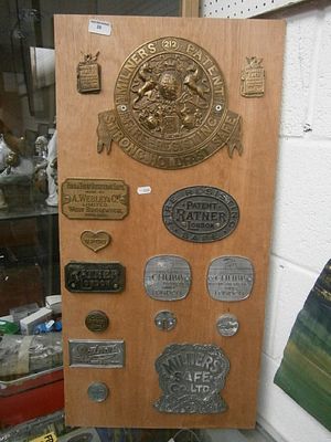 Board containing assorted brass and chrome Safe signs