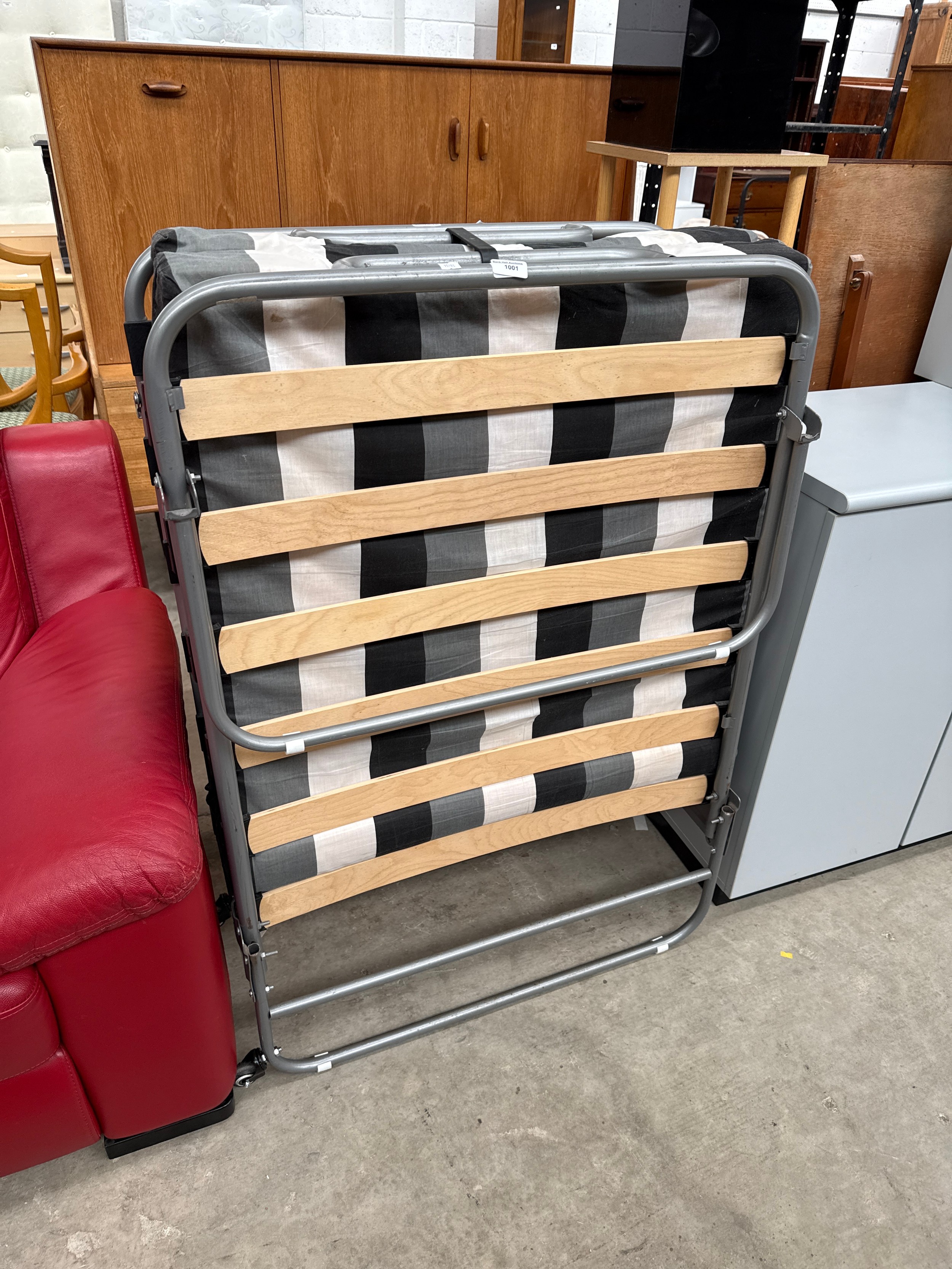 A folding single guest bed with mattress