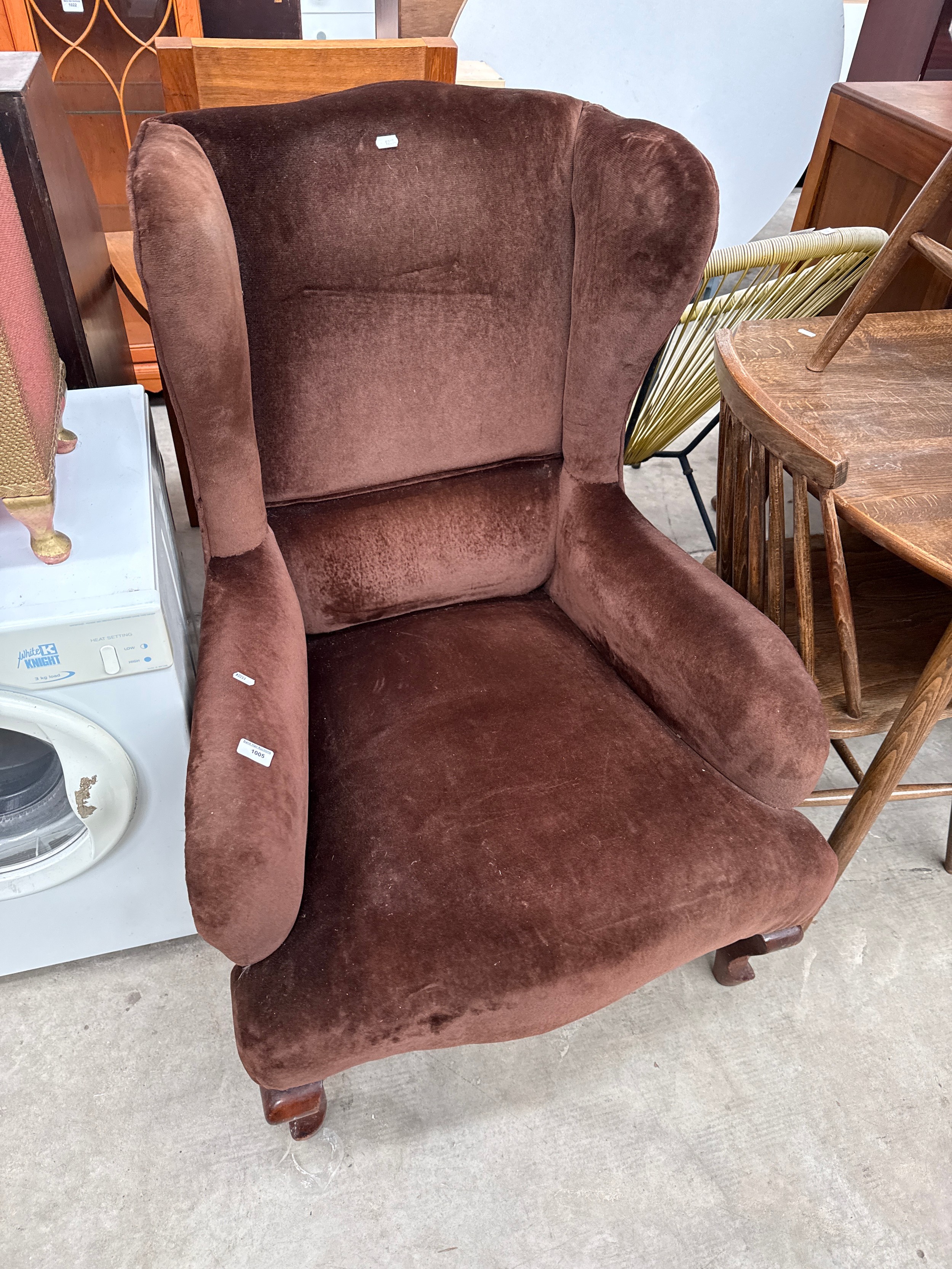 A vintage wing back armchair on Queen Anne style legs