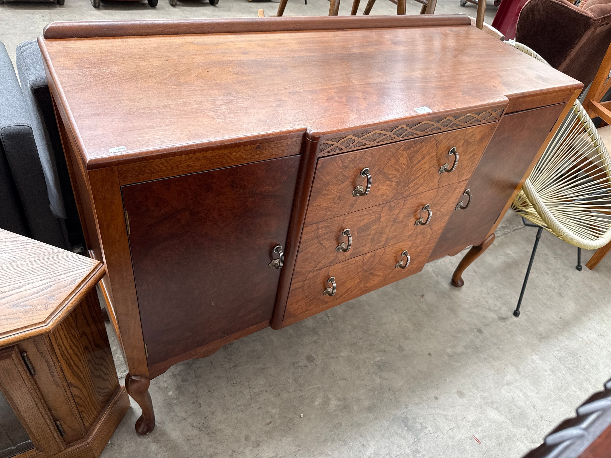 A vintage 3 drawer carved breakfront sideboard with fitted cupboard