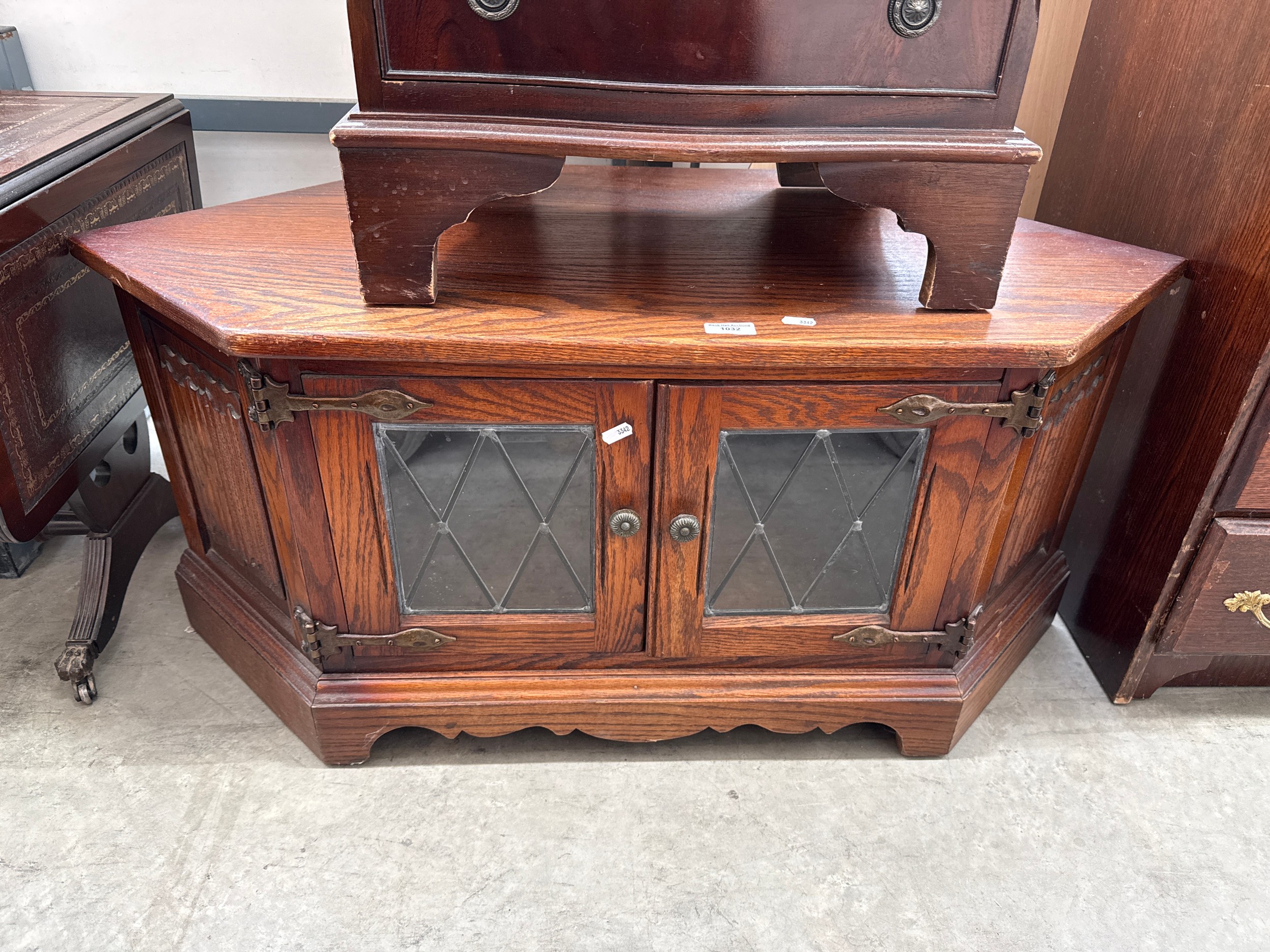 A small vintage oak corner TV stand cabinet with lead glazed doors