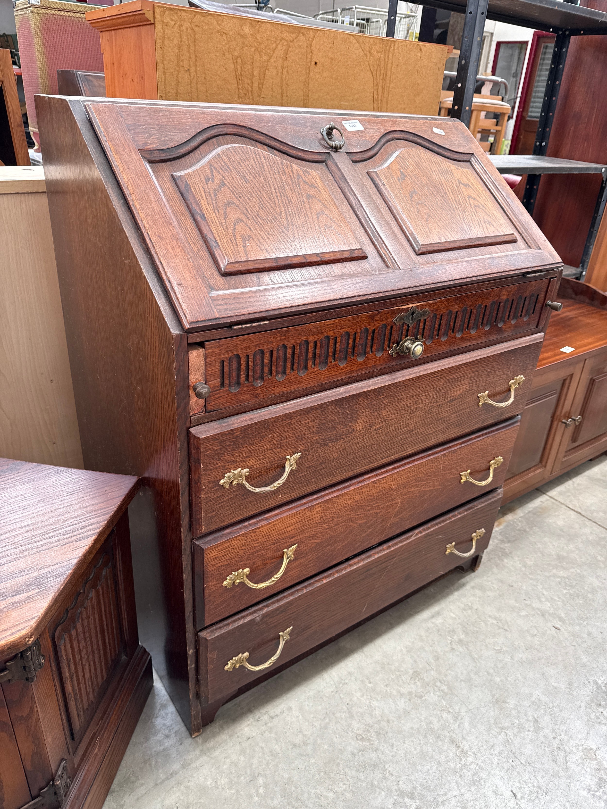 A vintage 4 drawer carved oak fall front bureau